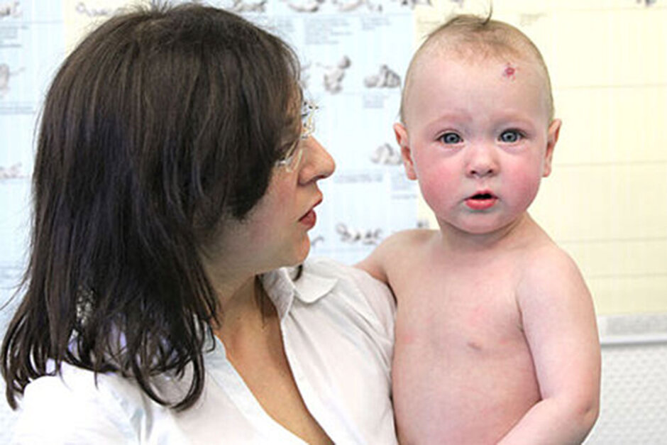 eine Mutter hält ein Kleinkind im Arm