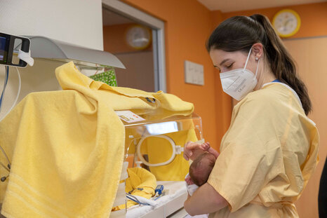 Kinderkrankenschwester mit Frühchen auf dem Arm
