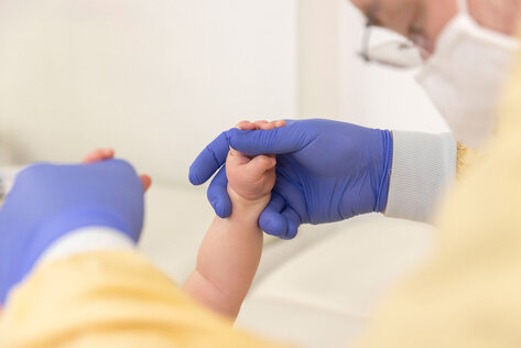 Ein Kinderarzt bei einer U-Untersuchung eines Kleinkinds